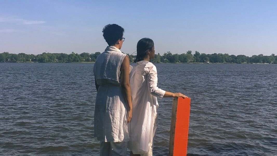 two people wearing white standing on pier