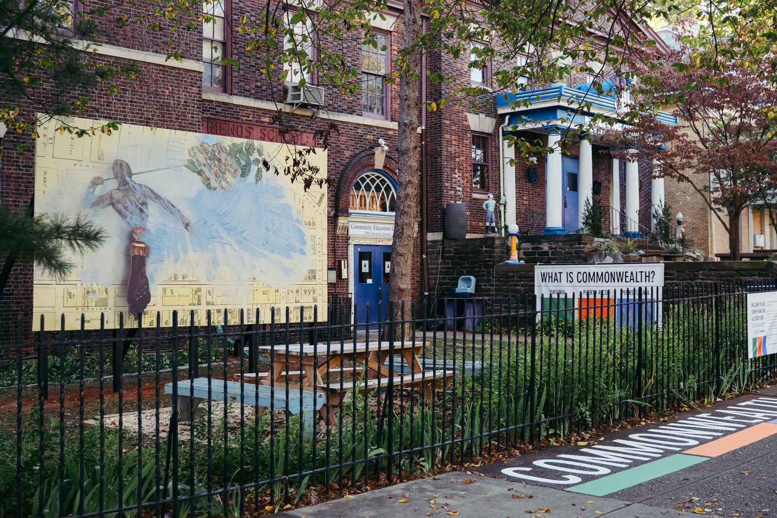 A shot of a mural in context. The mural shows a figure with large wings overlayed on a city plan.