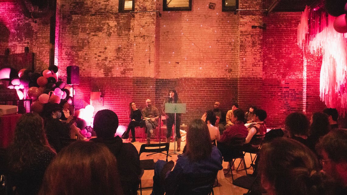 Speaker in front of microphone, delivers remarks to WAP attendees.